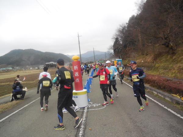 中央には折返点と書かれた赤いポールが立っていて、その周りを回りながら走って折り返すランナー達の写真